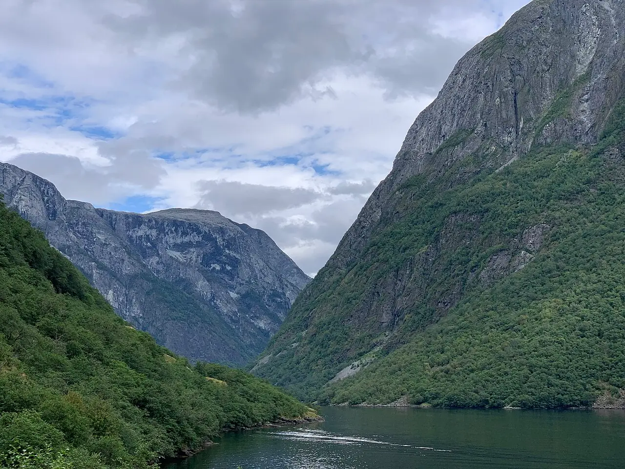 The calm water of the Nærøyfjord between towering mountain walls